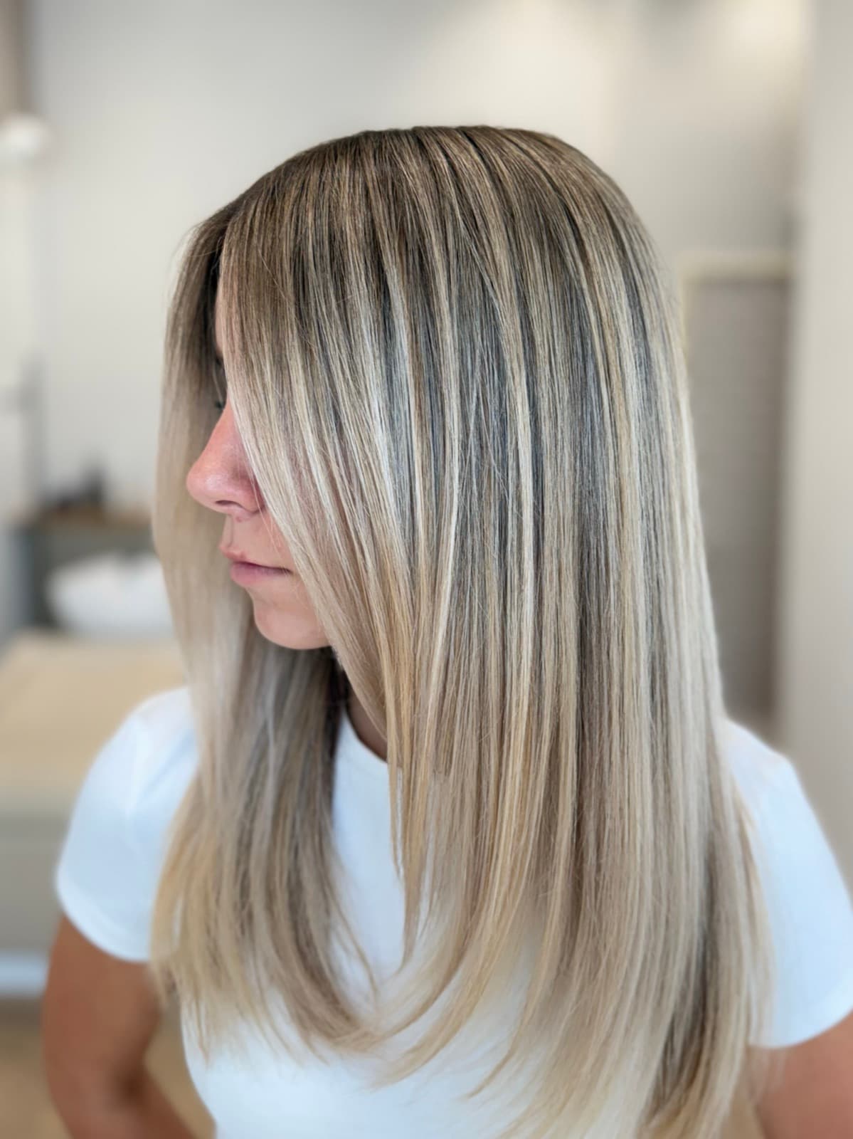 Blond nuancé sur cheveux lisses, racines fondues